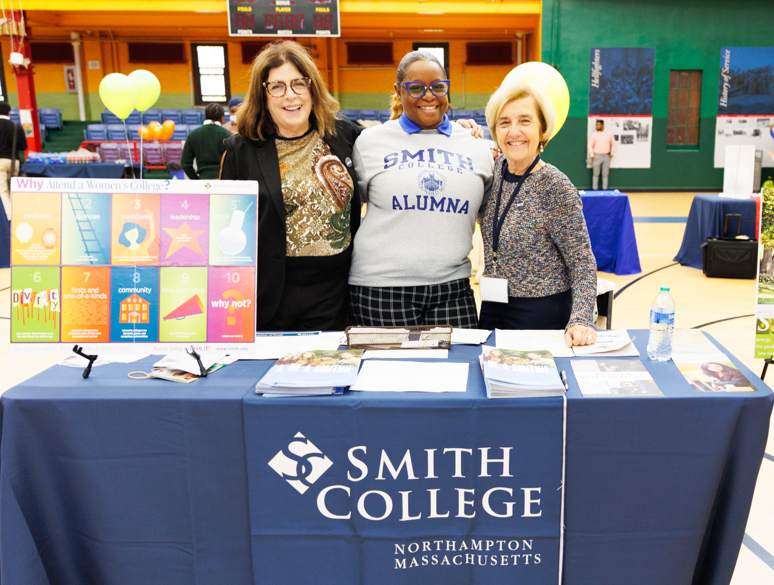 Three women from Smith College smile at a CHECS College Fair.
