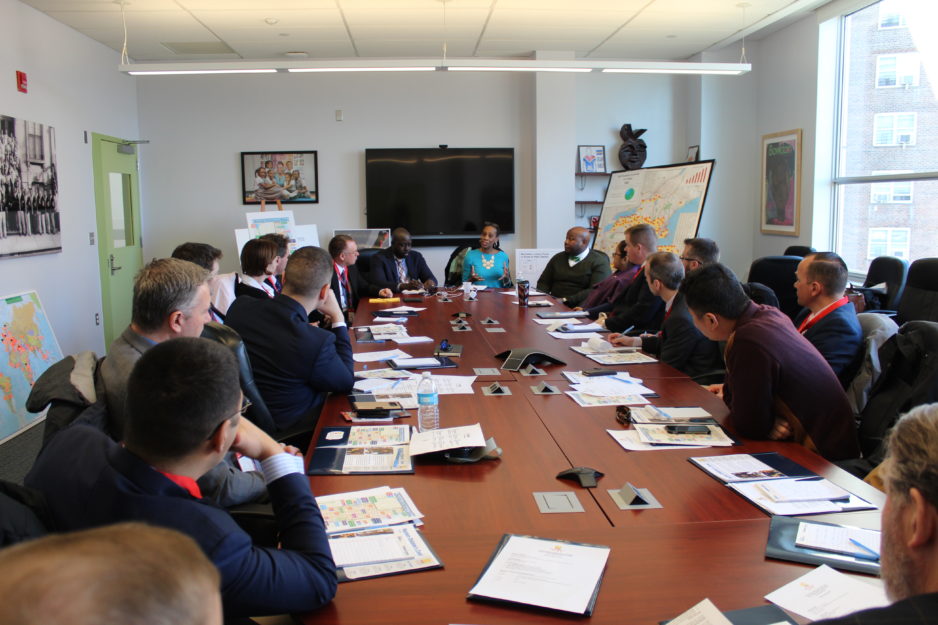 A group of people sit around a table for a meeting.