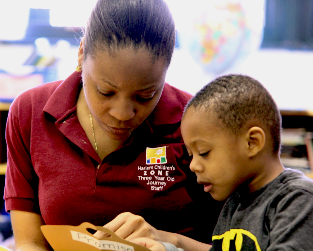 three-year-old journey | A teacher helps a young child as he learns to read.