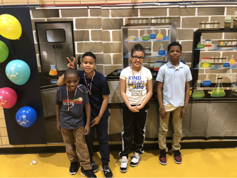 Four elementary grade Peacemakers students stand proudly together after winning a science fair