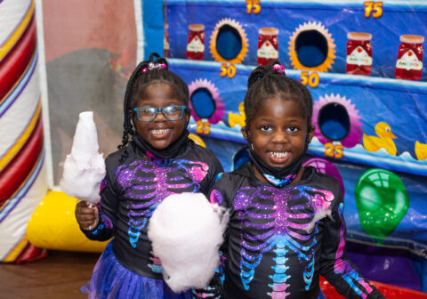 Two girls wearing multi-colored skeleton costumes at Haunted Fairytale at Harlem Children's Zone Geoffrey Canada Community Center.