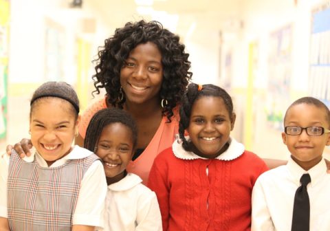 Children smiling with their teacher