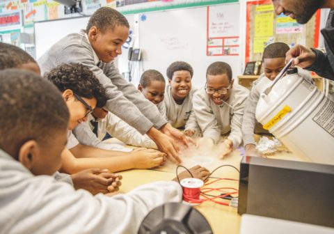 Young men huddled together doing a group science experiment