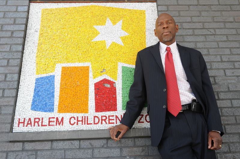 Geoffrey Canada stands next to Harlem Children’s Zone mural