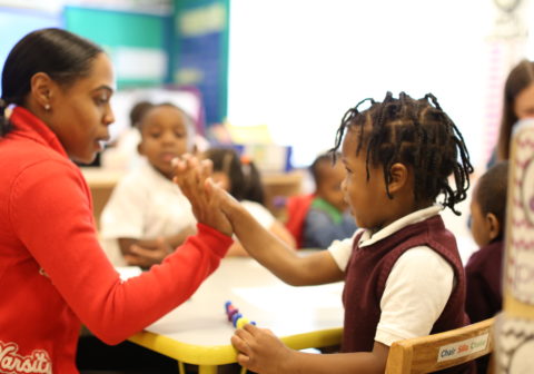 An instructor and young girl high five in class