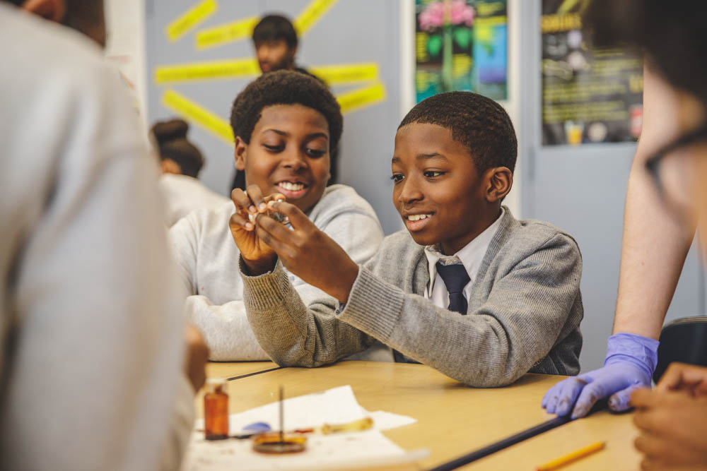 A two male students observe a shell in a science lab.