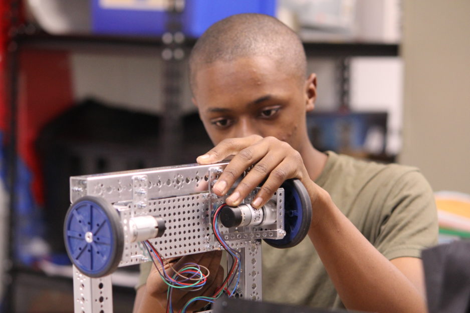 A high school student studies robotics.