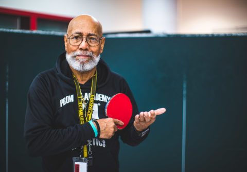 After School Athletics Specialist Donald Redd plays ping pong with his scholars.