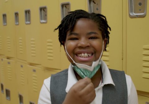 Girl smiling next to school lockers