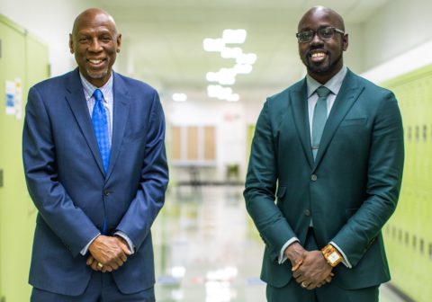 Harlem Children's Zone Founder and President Geoffrey Canada and CEO Kwame Owusu-Kesse standing together in the hallway of Promise Academy