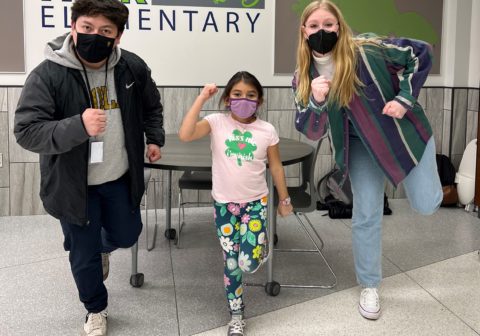 Two adults and a child, all wearing face masks, run in place.