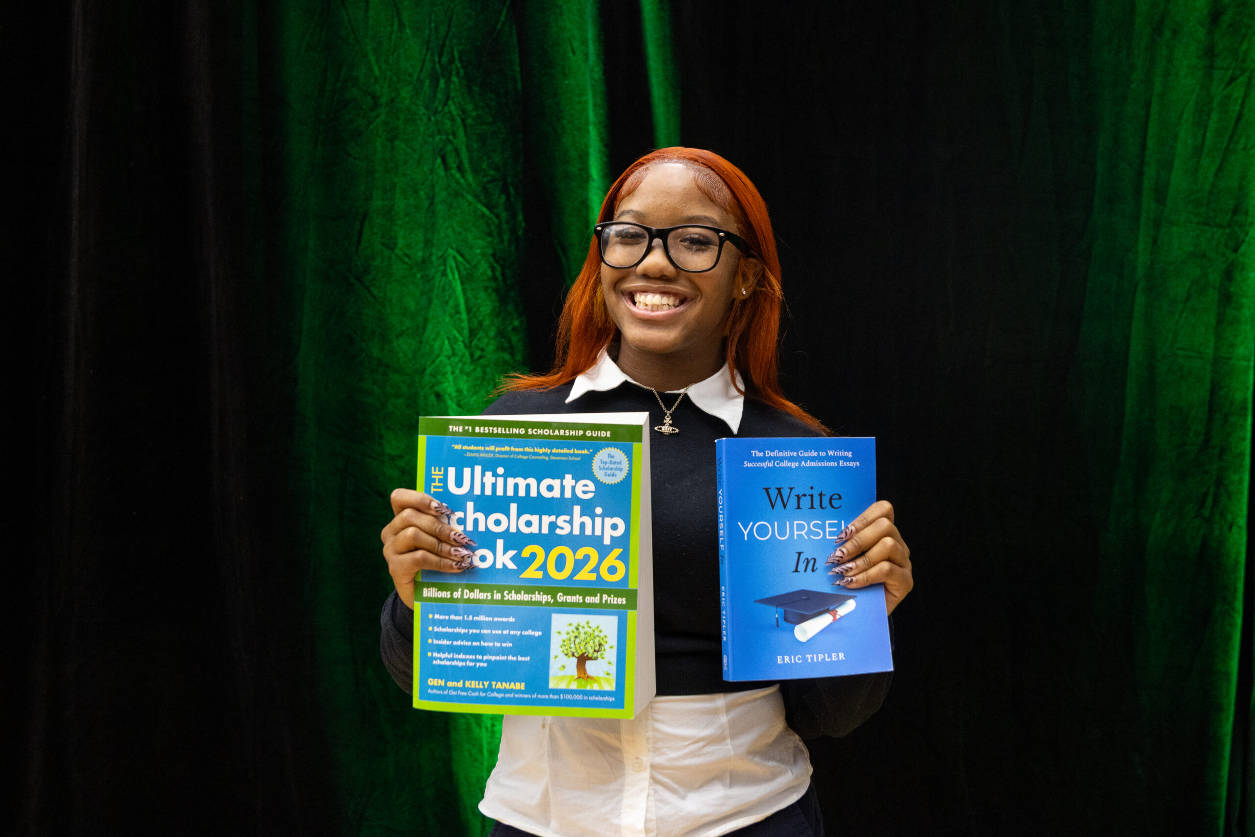 Young girl holds book about scholarships.