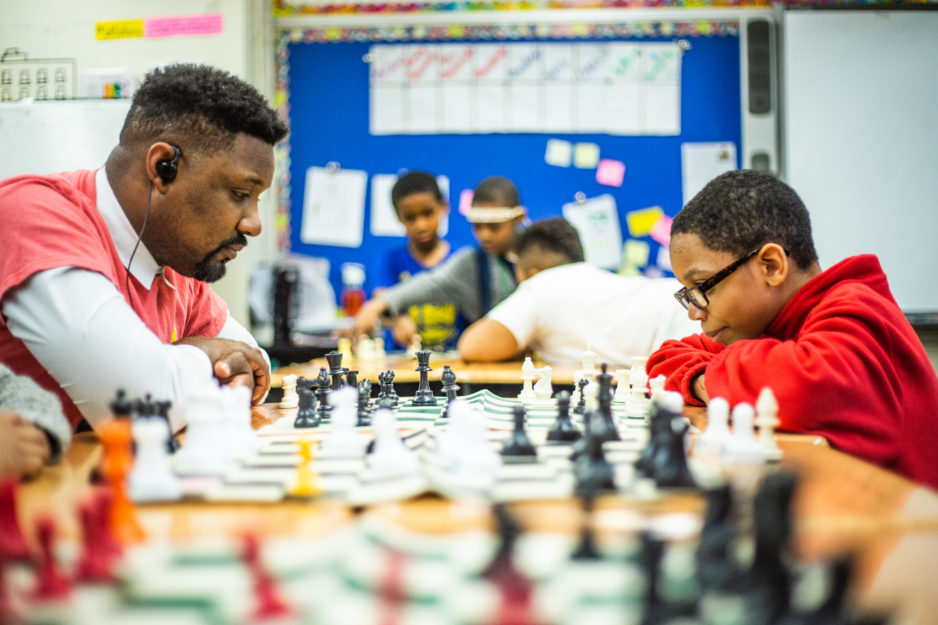 Promise Academy teacher and scholar play chess in classroom