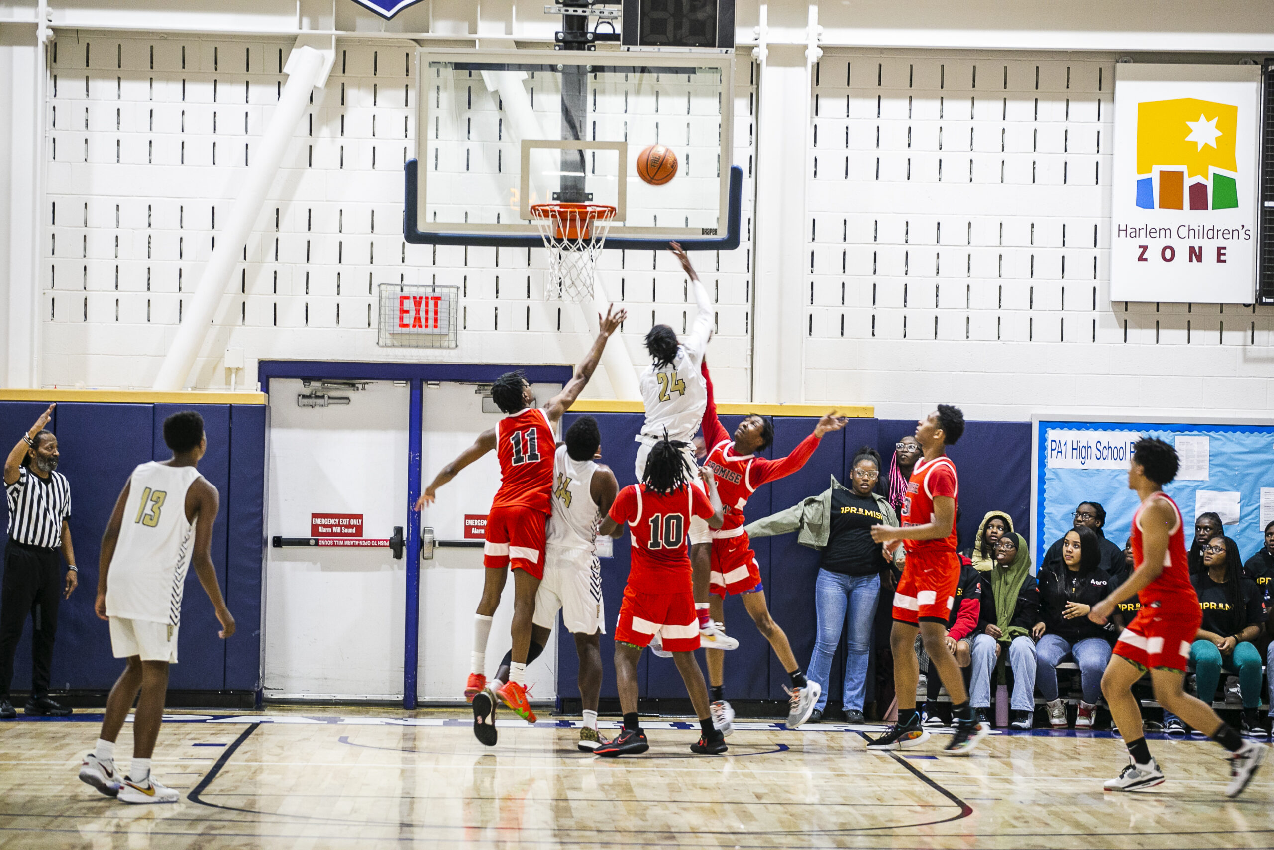 Scholars playing basketball in the gym.