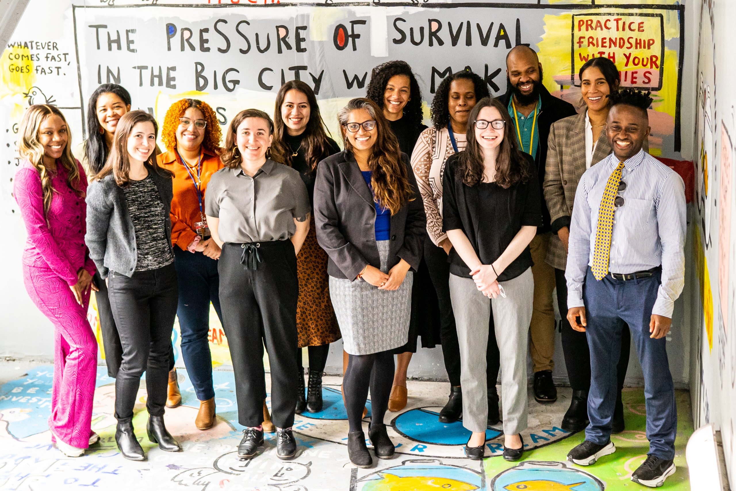 Promise Academy social services team stands in front of colorful mural