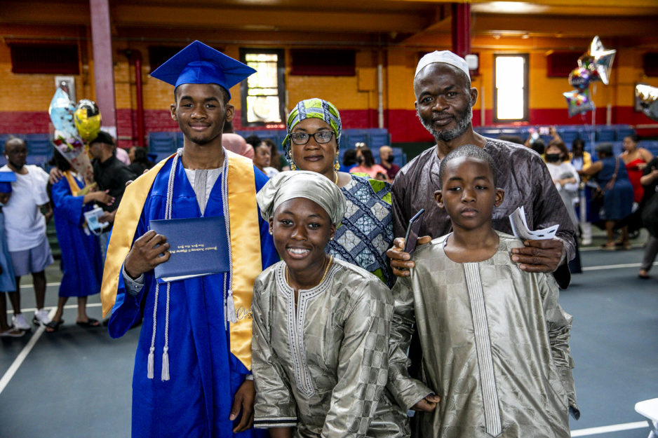 Promise Academy High School scholar and his family at graduation ceremony during Harlem Children's Zone Graduation Week 2022
