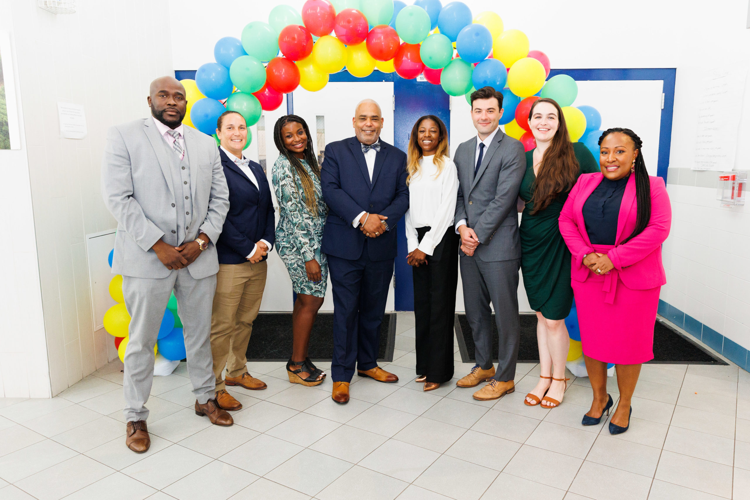 HCZ Promise Academy senior staff standing next to each other and multi-colored balloons