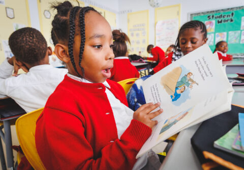 A student reads a book in a classroom.