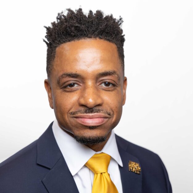 Man in black suit and yellow tie