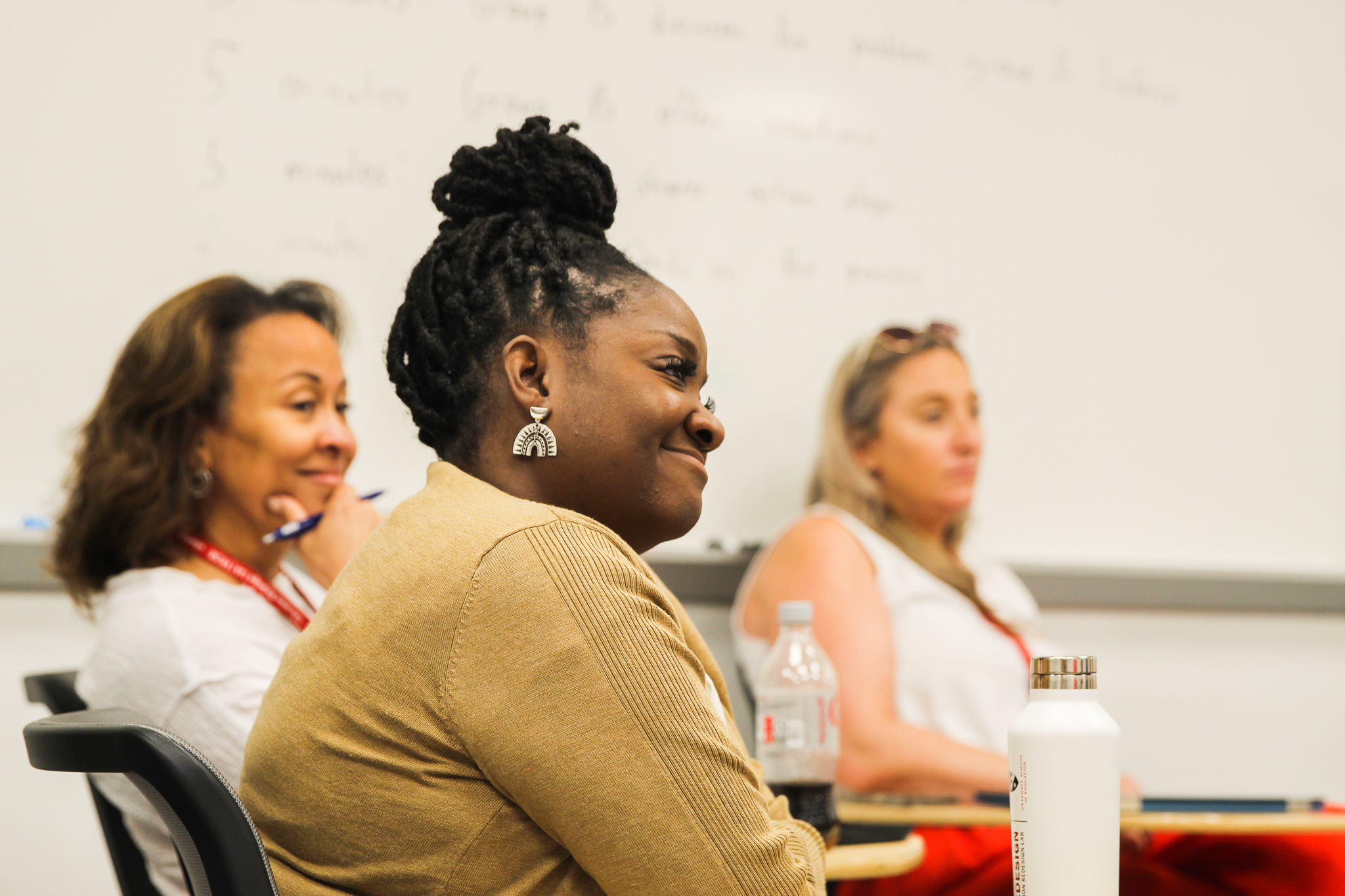 Profile view of 3 women seated and actively listening.