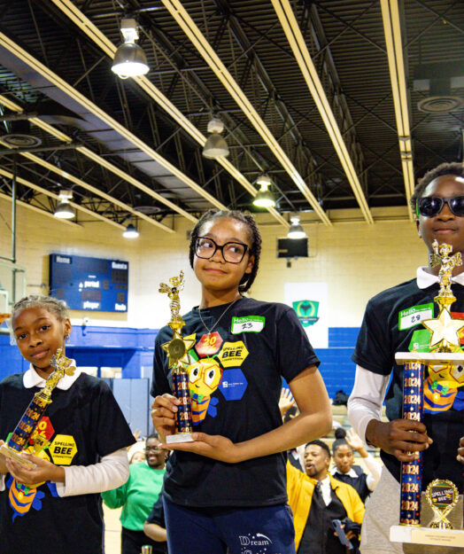 The 3 spelling bee champions pose with their trophies.