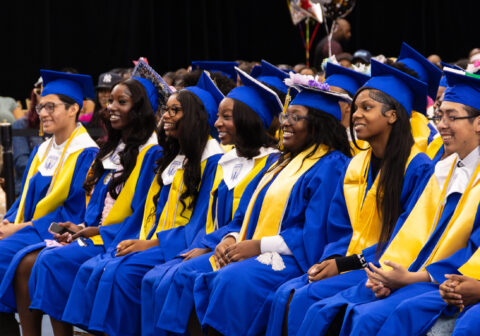 HCZ Promise Academy High School seniors sit and smile during graduation day at The Armory.