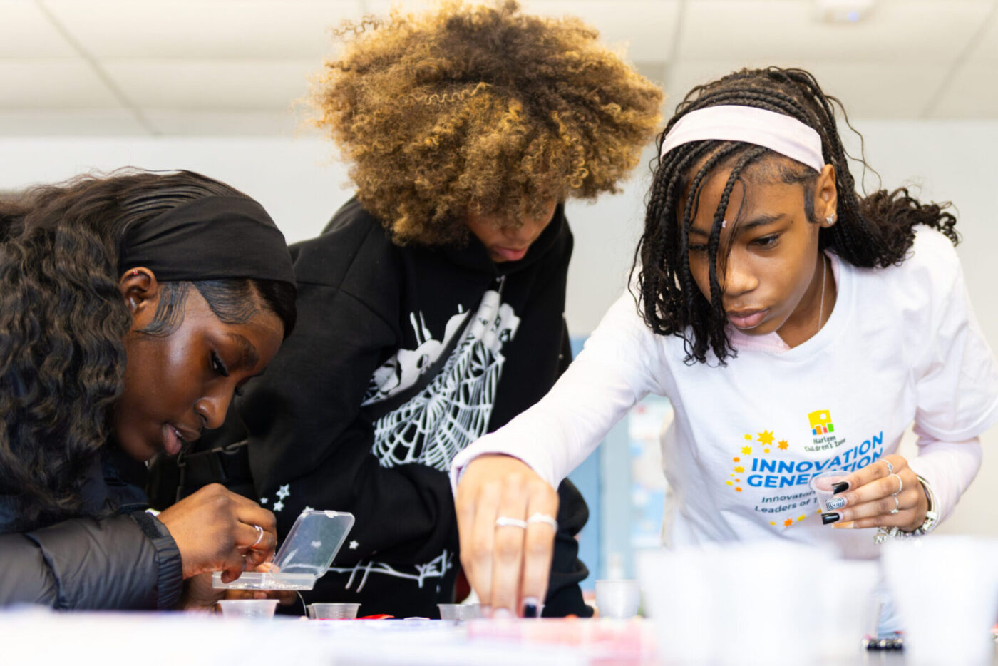 Three scholars actively work on a hands-on activity in class.