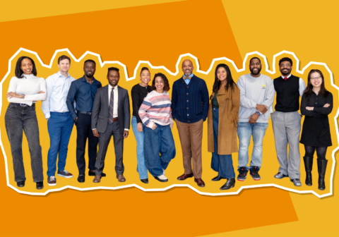 Group image of smiling workers dressed in business professional, with an orange background.